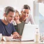 Report a Claim - Family Using the Computer at the Table
