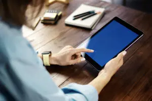Understanding Surety Bonds - Closeup of a Woman Using a Tablet to Access Her Account Information